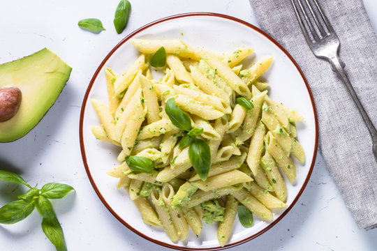 Vegan pasta penne with avocado and basil. 