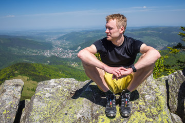 Hiker rests on the stone while hiking