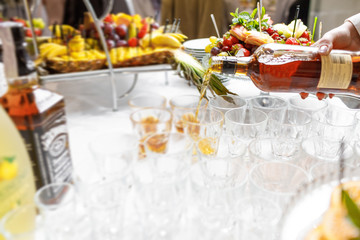 Barman pouring whiskey in crystal glasses