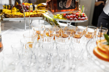 Barman pouring whiskey in crystal glasses