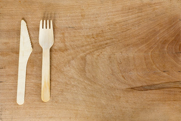 Wooden knife and fork on wooden background