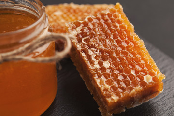 Golden honeycombs and honey jar, closeup