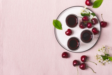Cherry alcohol drink liquor or brandy on pink background