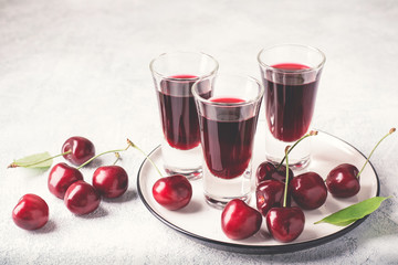 Cherry alcohol drink liquor or brandy on pink background