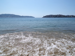 Sandy beach at bay of ACAPULCO city in Mexico with fabulous panoramic view and waves of Pacific...