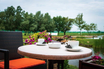 two cups of espresso coffee and ashtrays on the terrace table