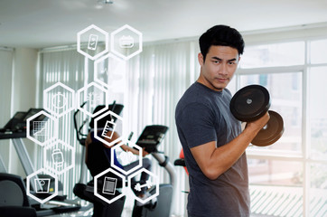 young handsome man doing exercise with dumbbell for good healthy in fitness gym with woman on bicycle machine background with graphic icon diagram, bodybuilder, workout and sport training concept