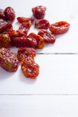 sun dried whole tomatoes on white wood table background