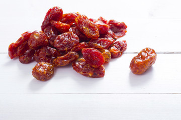 sun dried whole tomatoes on white wood table background