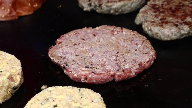 Close up of grilling beef meat burgers and vegetarian quinoa burgers for hamburgers, high angle view