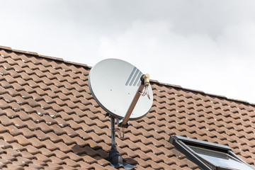 TV satellite dish on a red tile roof