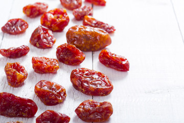sun dried whole tomatoes on white wood table background
