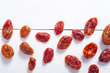 sun dried whole tomatoes on white wood table background
