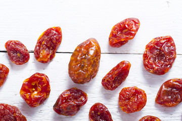 sun dried whole tomatoes on white wood table background