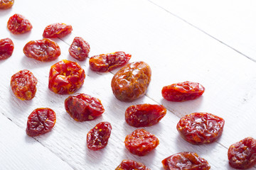 sun dried whole tomatoes on white wood table background