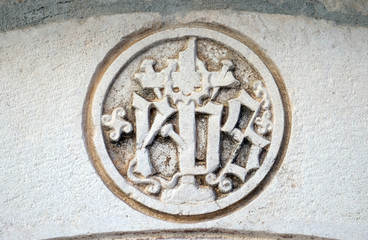 IHS sign on church facade in Korcula, Croatia 