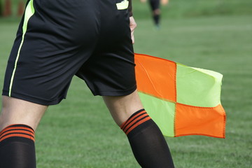 Fototapeta premium Assistant referees in action, holding the flag, during a soccer match