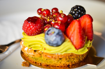 delicious fresh tarts with fruits - strawberry, blackberry, raspberry, red berry & pistachio cream