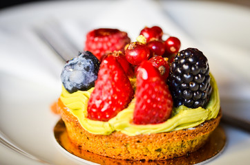 delicious fresh tarts with fruits - strawberry, blackberry, raspberry, red berry & pistachio cream