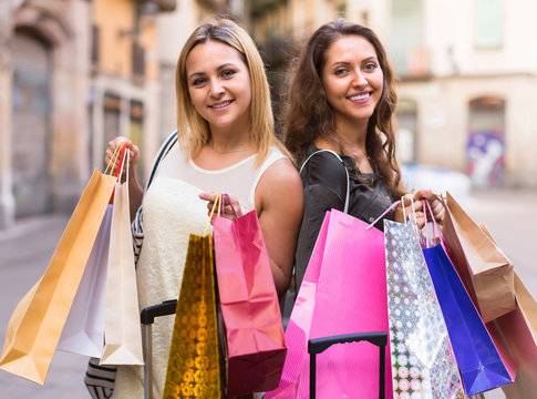 Two young women holding shopping bags.