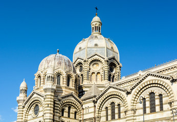 Fototapeta na wymiar Close-up view of the dome of Sainte-Marie-Majeure cathedral in Marseille, known as La Major, a neo-byzantine style catholic building achieved in 1893, showing several cupolas, chapels and turrets.