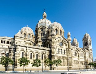 Three-quarters rear view of the cathedral of Marseille, Sainte-Marie-Majeure also known as La Major, a neo-byzantine style building in La Joliette district, showing cupolas, chapels and turrets.