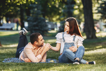 Family photo. Pregnant couple spending time outdoors sitting in the park chatting. Pregnancy, leisure, healthy lifestyle, marriage, relationships, motherhood, fatherhood, love, happiness concept