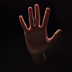 Man making stop sign with his hand at black background