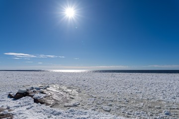 Spring time ice on sea with crisp sunshine and blue sky