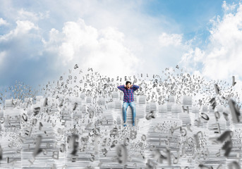 Attractive man sitting on pile of paper documents.