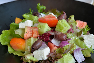 Greek salad in black bowl