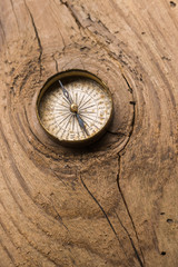 Fototapeta na wymiar Old vintage compass on cracked wood plank