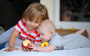 Bébé petit frère veut manger la pomme de son grand frère