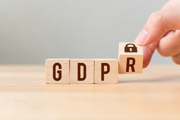 Hand flip wood cube block with word GDPR. Concept legal EU protect information general data protection regulation and sign key icon