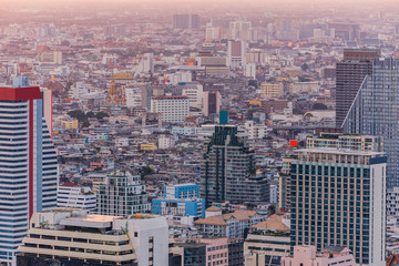 Fototapeta na wymiar Aerial view of Bangkok modern office buildings, condominium in Bangkok city downtown at the dusk. With golden and purple sky.