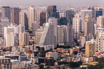 Aerial view of Bangkok modern office buildings, condominium in Bangkok city downtown at the dusk. With golden and purple sky.