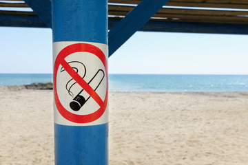 close up of no smoking sign over tropical sand beach