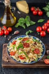 Italian pasta with sauce, cherry tomatoes, basil and parmesan cheese. Delicious pasta plate. Vegan pasta. 