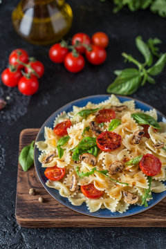 Italian pasta with sauce, cherry tomatoes, basil and parmesan cheese. Delicious pasta plate. Vegan pasta. 