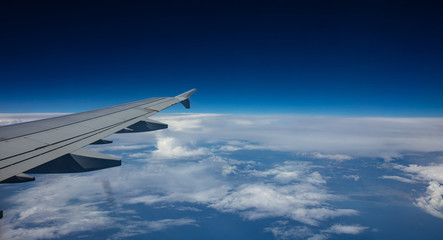 Fototapeta na wymiar Plane wing on blue sky background