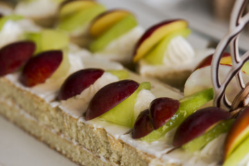 Cake decorated with cream, slice of grapes,   on a white plate. Selective focus