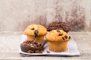 Homemade muffins with chocolate, vintage background.