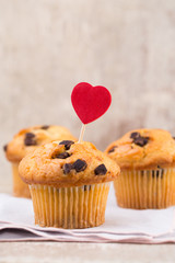 Homemade chocolate muffins with heart, vintage background.