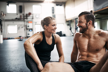 Smiling young couple taking a break from working out together