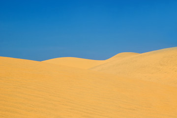 Fototapeta na wymiar View on hills in a desert with blue sky.