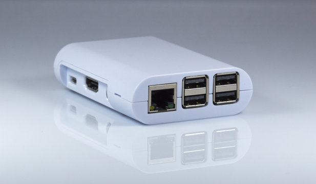 RJ45 and USB ports of tiny computer. On mirror table.