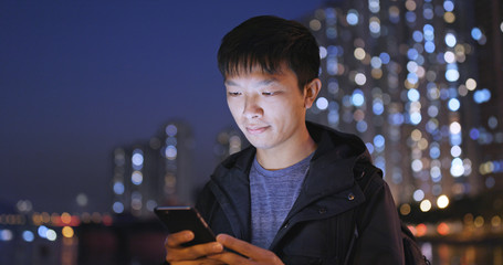 Man use of mobile phone in city at night