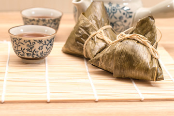 Zongzi - Traditional Dragon Boat Festival dumpling. Hand drawn watercolor painting isolated on wood background.