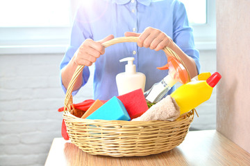 Professional cleaning woker from service holds a basket with household chemicals for home cleaning