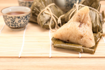 Zongzi - Traditional Dragon Boat Festival dumpling. Hand drawn watercolor painting isolated on wood background.